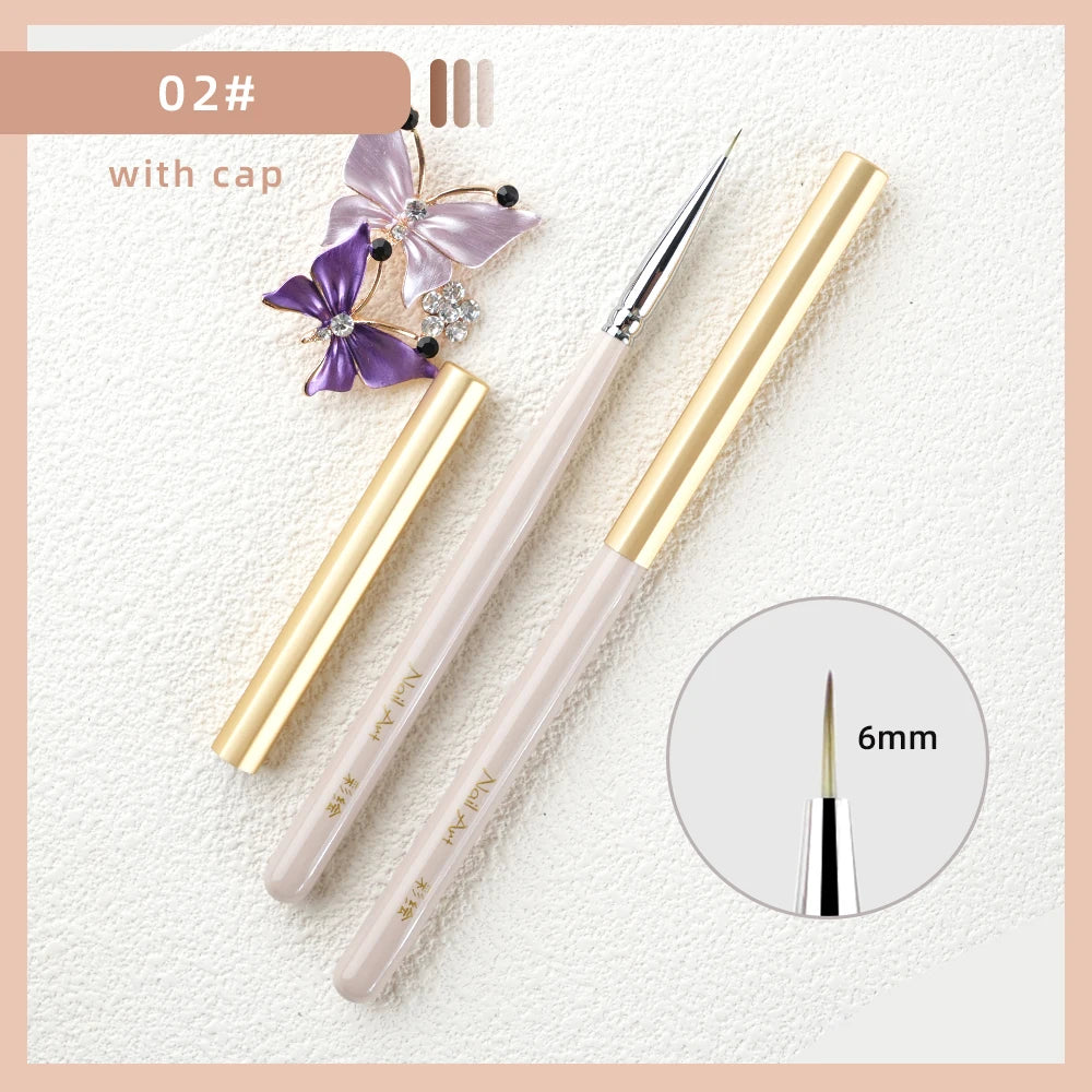 A set of professional nail art brushes with gold and pink handles, including a fine point brush.