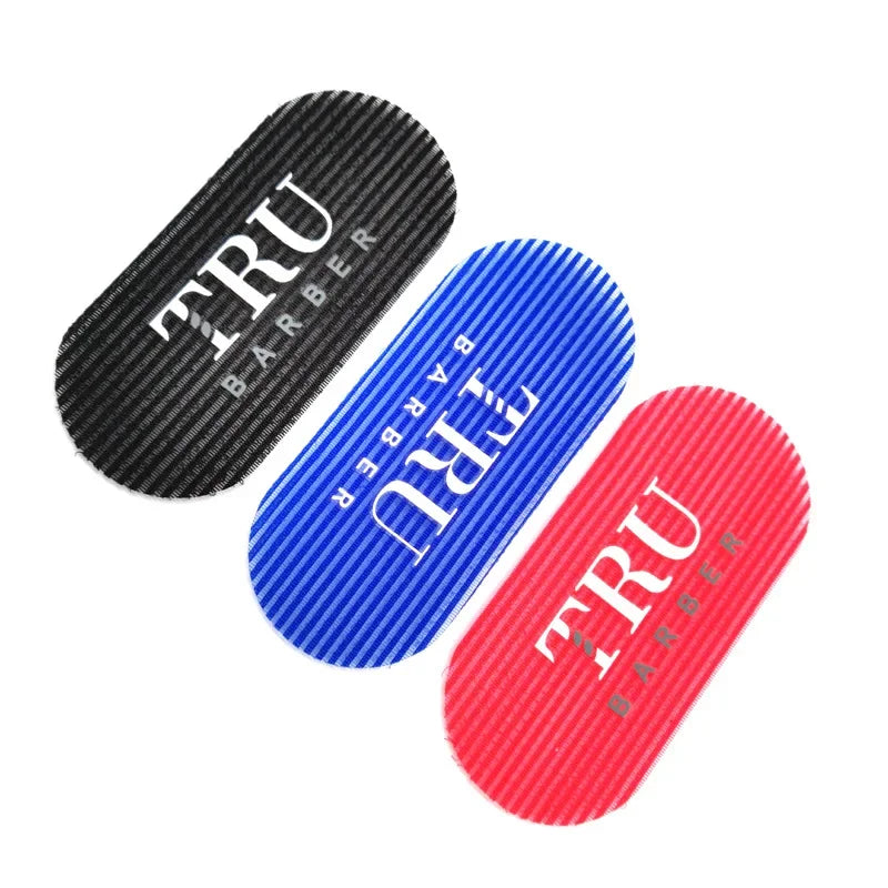 Trois pinces ou outils de coiffure en noir, bleu et rouge.