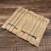 A set of eco-friendly bamboo toothbrushes packaged in individual paper sleeves.