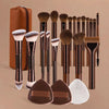 A collection of 14 professional makeup brushes and sponges in various shades of brown and black.