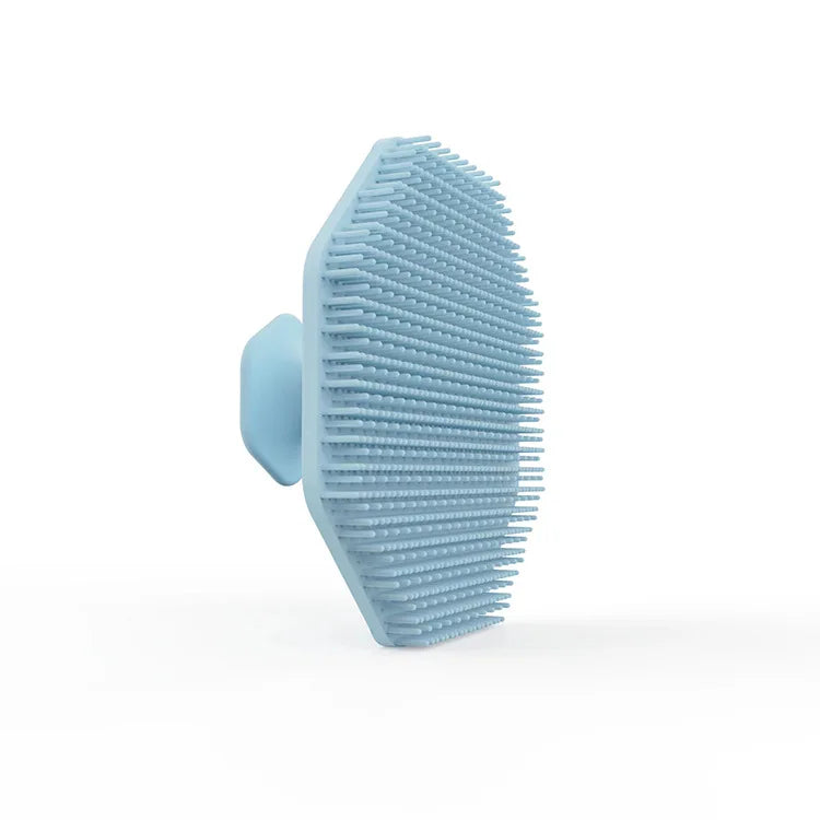 A light blue silicone facial cleaning brush with dense bristles shown from the side.
