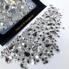 A close-up of a mixed glass rhinestone kit for nail art and DIY crafts showing various clear and silver rhinestones.