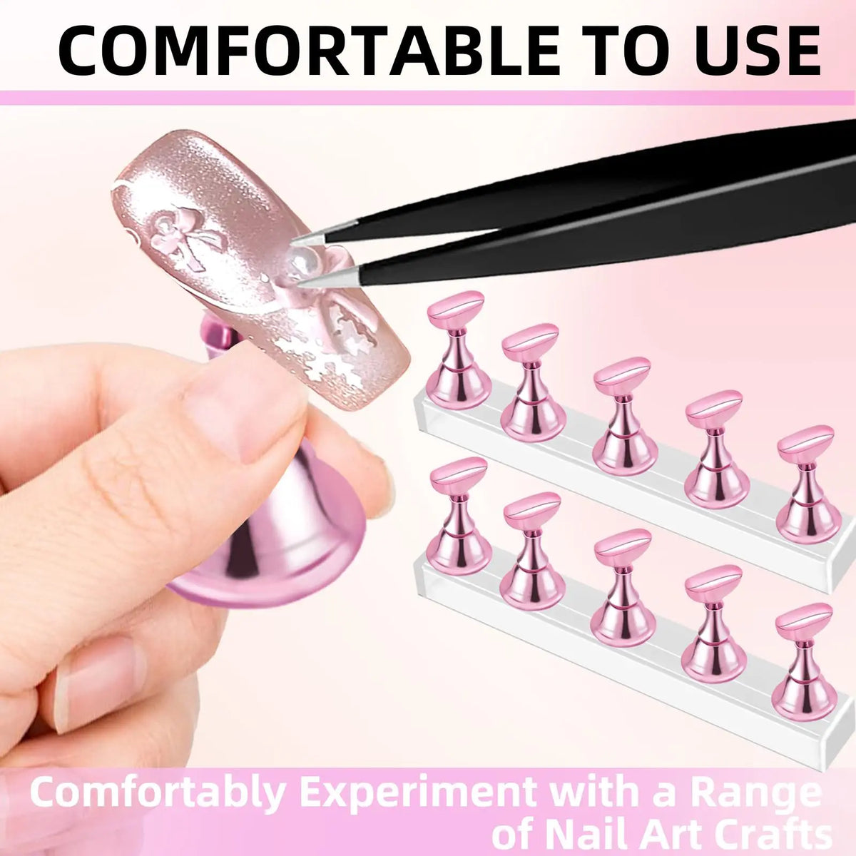 A hand uses a tool to apply pink nail art to a nail practice stand set for experimenting with nail crafts.