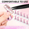 A hand uses a tool to apply pink nail art to a nail practice stand set for experimenting with nail crafts.