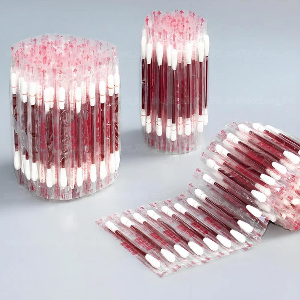 A collection of disposable medical iodine cotton swabs in pink and white are displayed in various forms.