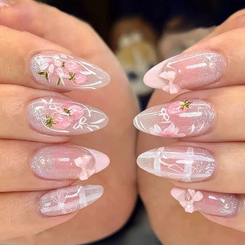 Close-up of pink cat eye false nails featuring delicate 3D floral and butterfly designs on a hand.