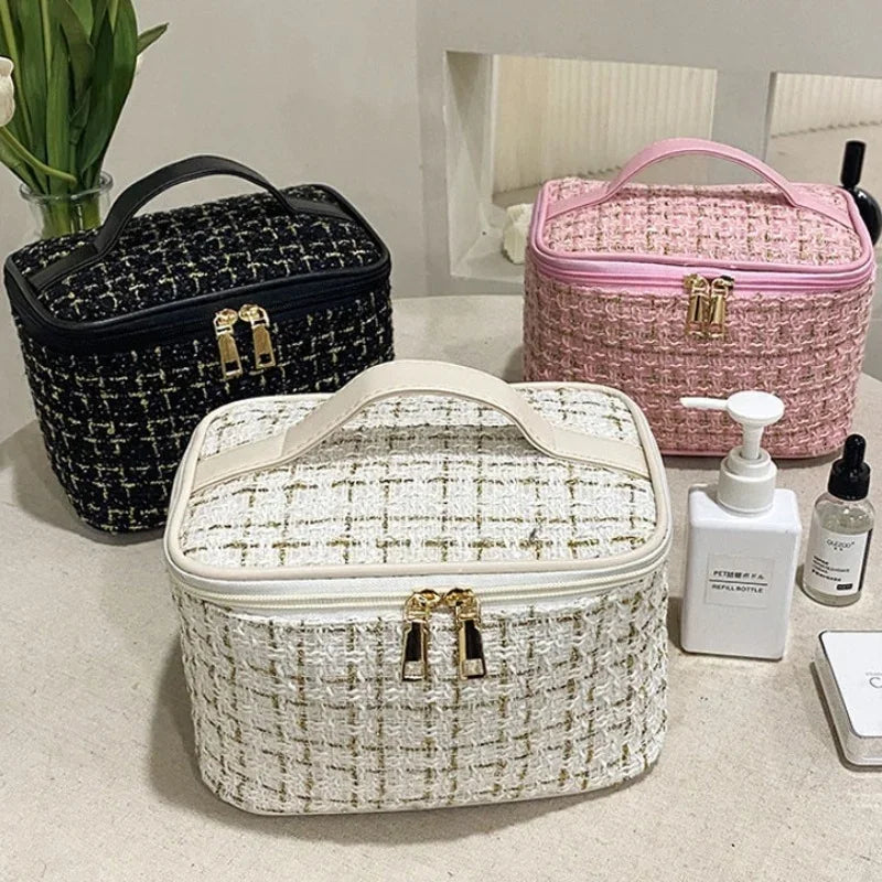 Three knitted canvas makeup pouches in black, pink, and off-white are displayed on a white surface.