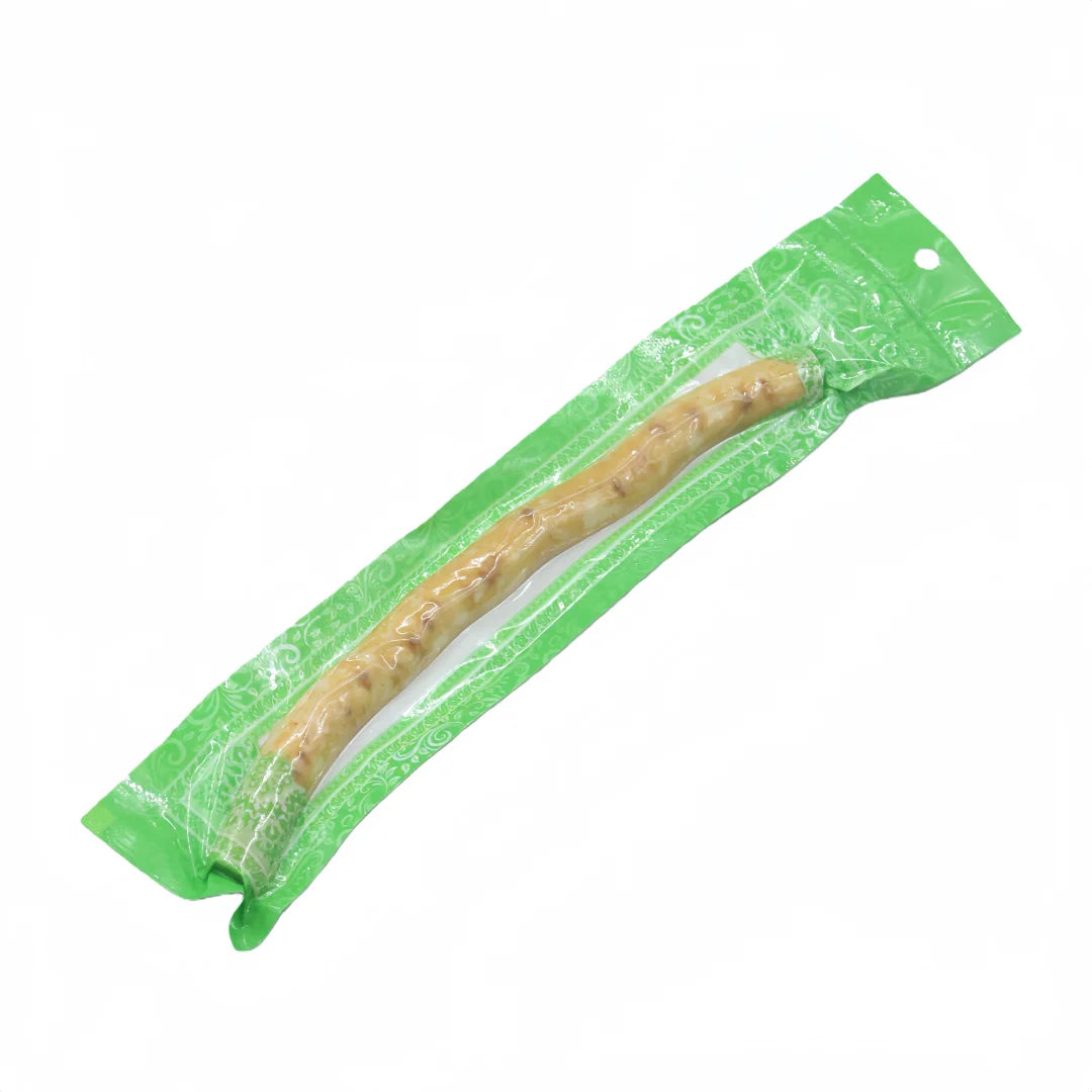 Une cure-dent miswak naturel est visible dans une pochette en plastique vert.