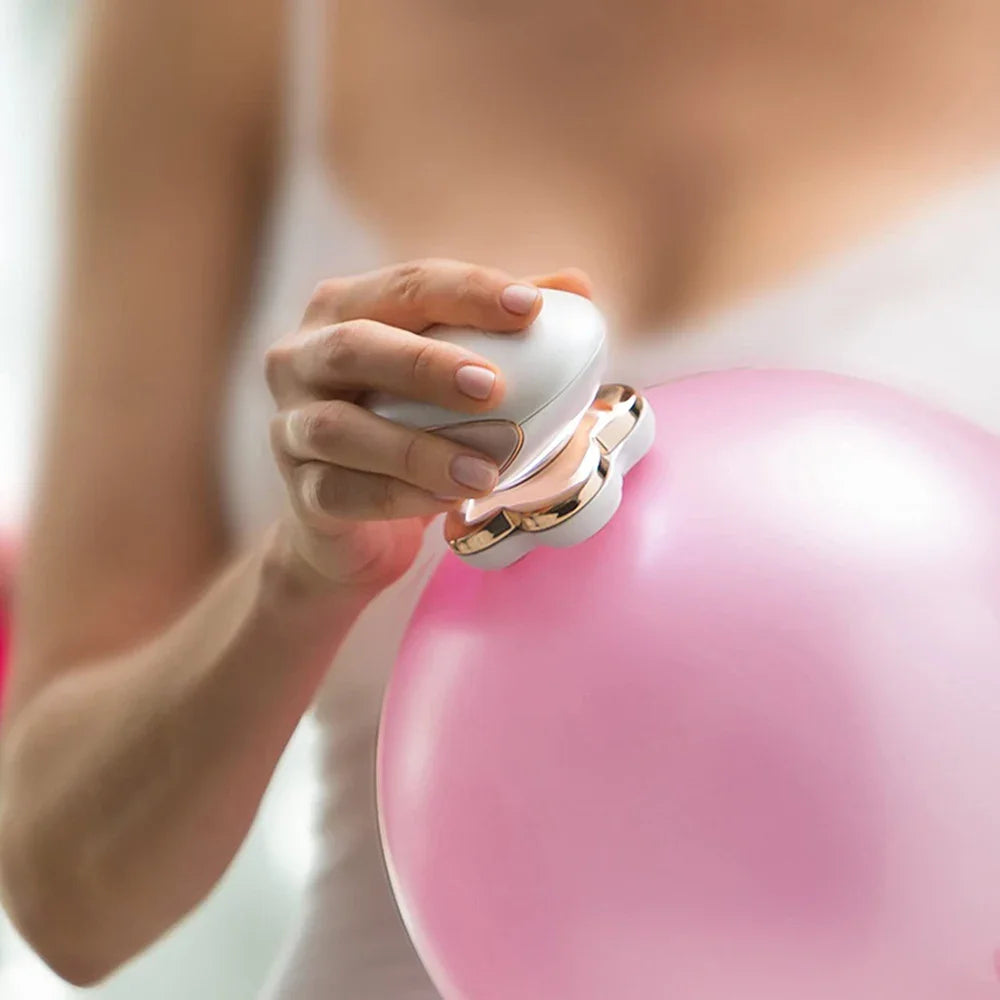 Una mano sostiene un dispositivo epilador eléctrico multifunción blanco contra un globo rosa.