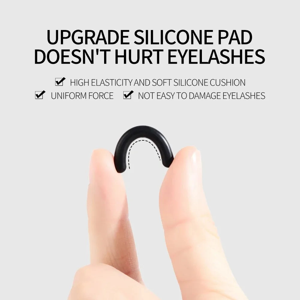 A hand is holding a black silicone eyelash curler, demonstrating its use for curling eyelashes.
