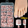 Una colección de 120 uñas postizas en varios tonos rosa y nude mostradas en un pie.