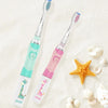 A pink and teal kids electric toothbrush with a giraffe design is shown on a white background.
