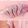 Un ensemble de peignes pour cheveux roses et iridescents avec des confettis colorés et des dessins d'animaux de dessins animé