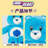 Close-up view of a blue Care Bear plush stuffed animal doll with large eyes and a light blue background.