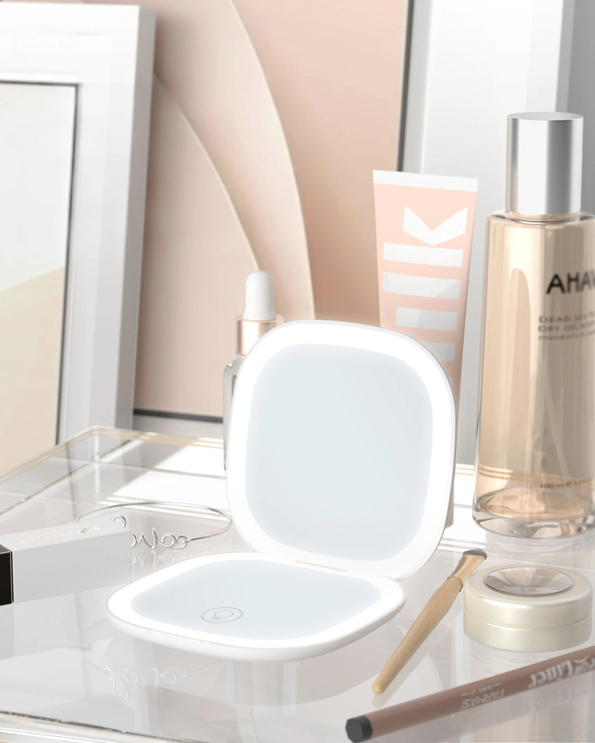 A compact LED makeup mirror with a white frame and a clear magnifying lens is shown on a glass surface.