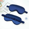 A dark blue double-sided silk eye mask is shown on a white background next to a box labeled CHANEL.