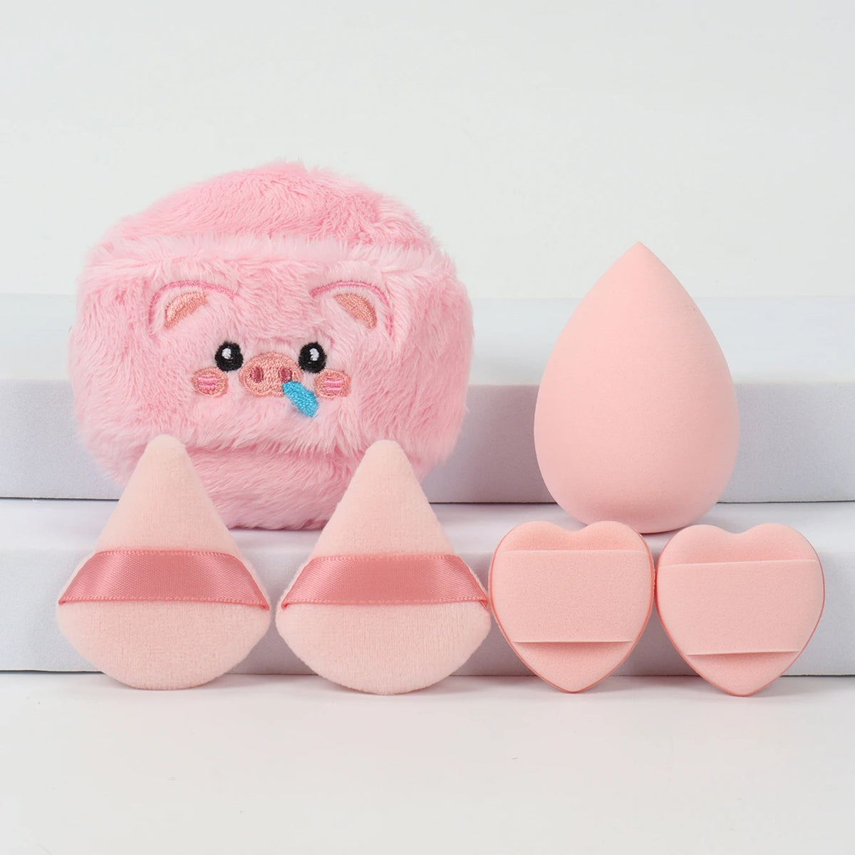 Un ensemble de poudrettes roses, incluant un ours rose duveteux et plusieurs poudrettes en forme de cœur roses.
