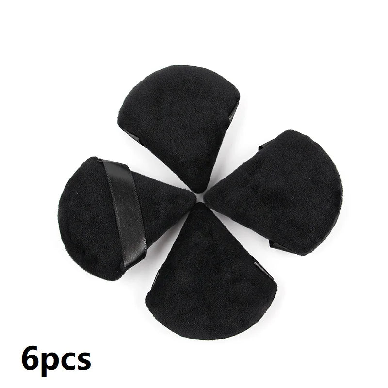 A set of six black velvet powder puffs arranged in a star shape.