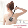 A woman is using a silicone back scrubber brush with a long handle on her back for cleansing.