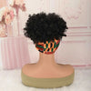 A black afro puff turban wig displayed on a mannequin against a pink and white background.