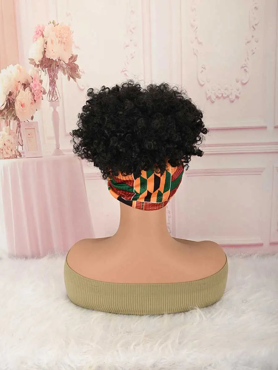 A black afro puff turban wig displayed on a mannequin against a pink and white background.
