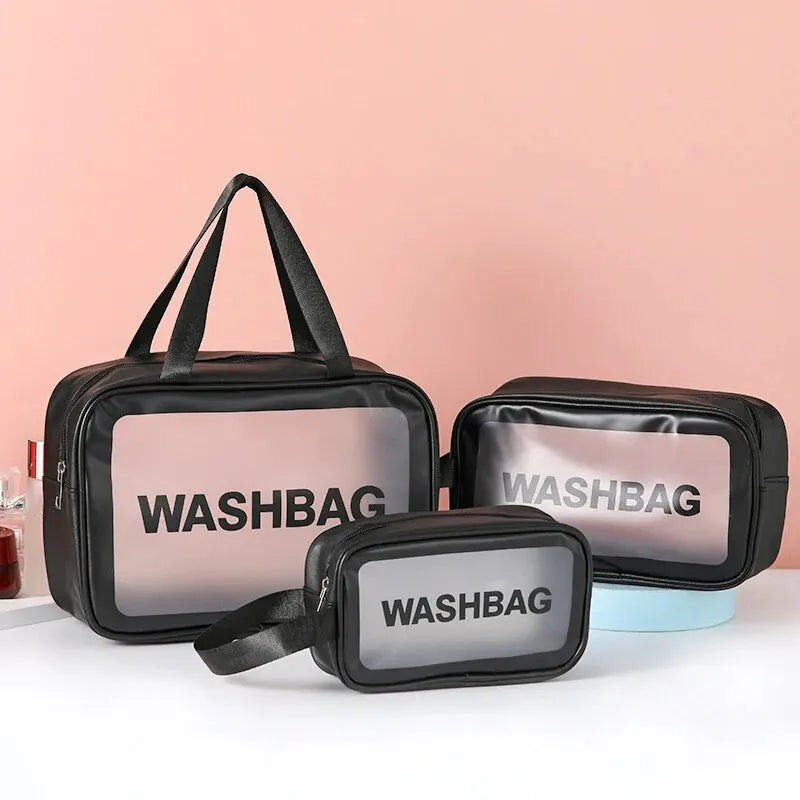 A set of black cosmetic storage bags with transparent windows and WASHBAG text displayed on a pink background.