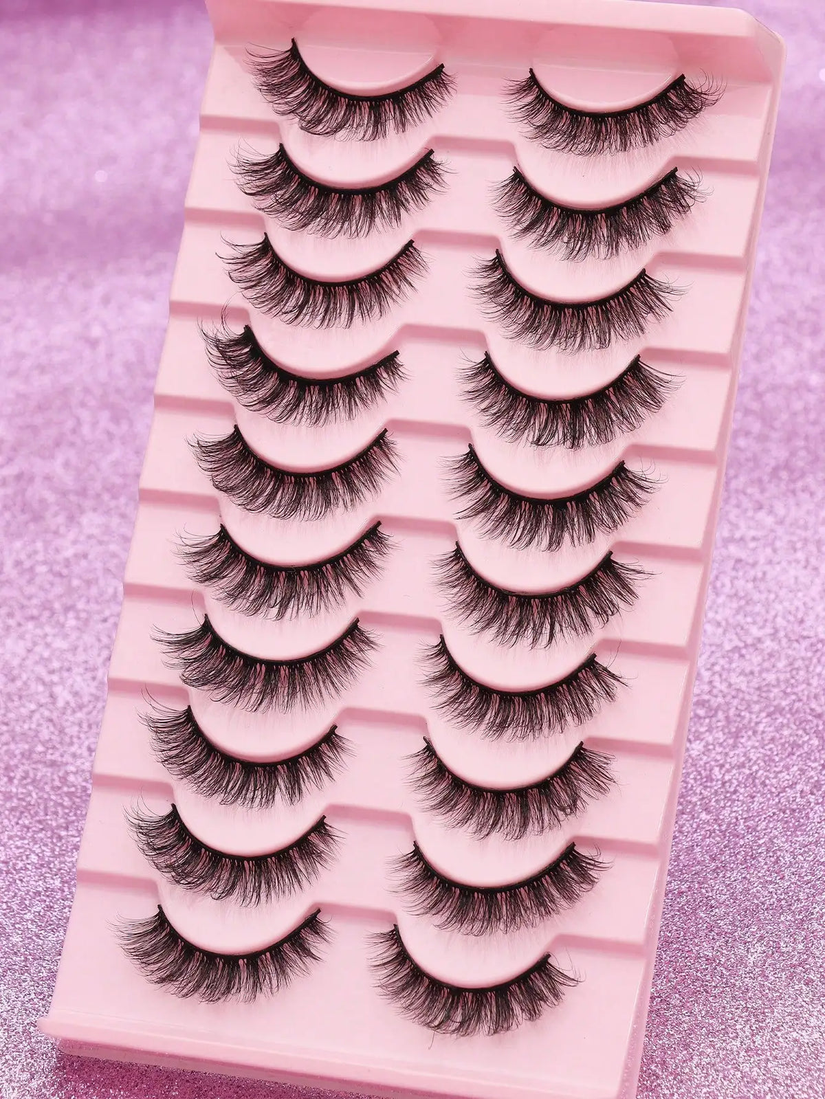 Pinkes Plastikgefäß mit einem Set dramatischer Mink-Falscheyelashs für Augen-Make-up.