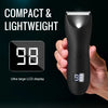 A hand holds a black professional body and personal hair trimmer with an ultra large LCD display showing 98.