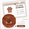 Un petit ours en peluche brun et duveteux à côté d'une carte d'identité avec les mêmes détails du personnage.
