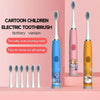 A set of cartoon children electric toothbrushes in pink and yellow colors with battery versions displayed on a wooden surface