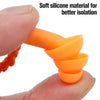 Une main serre un bouchon d'oreille en silicone orange, démontrant sa matière souple pour une meilleure isolation.