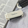 A folding mini hair comb with a mirror for styling, shown against a background of printed text.
