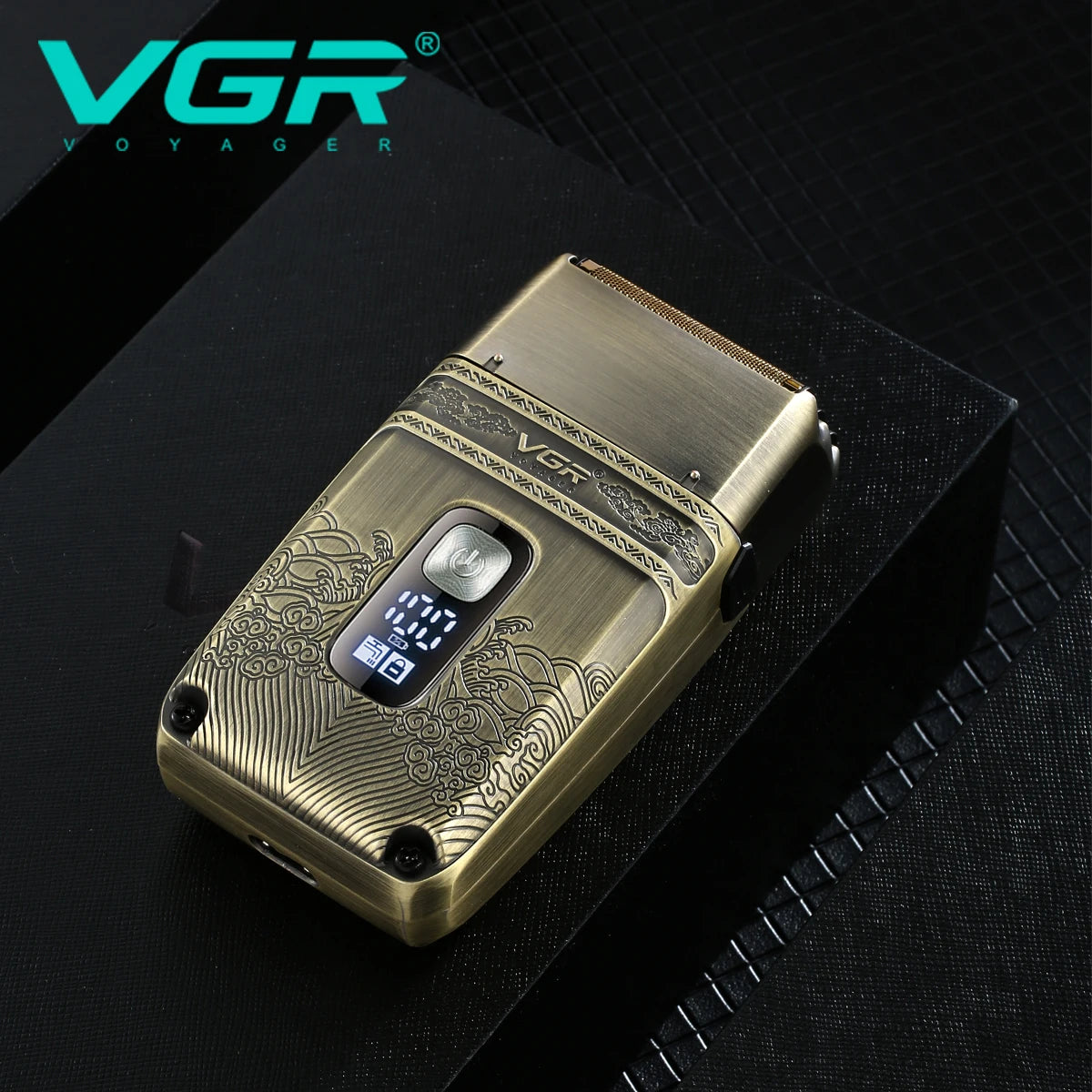 A gold-colored electric hair trimmer set resting on a black surface.