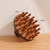 A wooden massage comb with natural sandalwood therapy features 12 widely spaced, rounded teeth.
