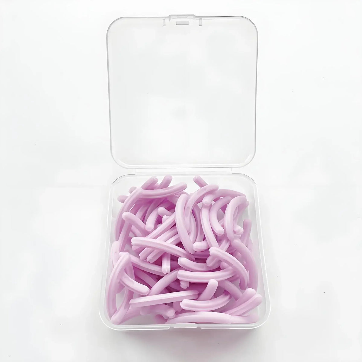 A clear plastic container holds 30 reusable silicone eyelash curler pads in a light purple color.