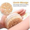 A hand is holding a natural bristle body brush with small white nodules, demonstrating gentle massage for muscles while bathi