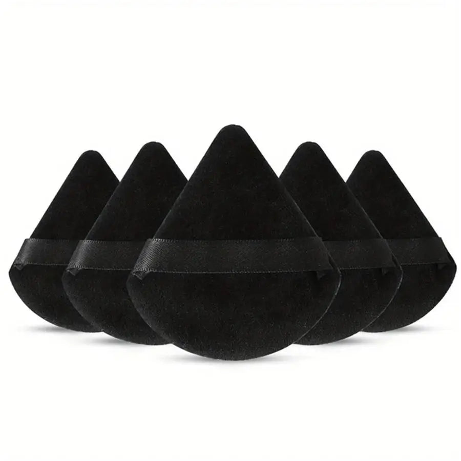 A set of black triangular powder puffs for flawless foundation application.