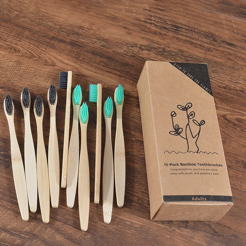 Une boîte contenant dix brosses à dents en bambou est présentée sur une surface en bois.