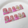 Un set de uñas postizas de flores rosa nude decoradas con purpurina y perlas rosas.
