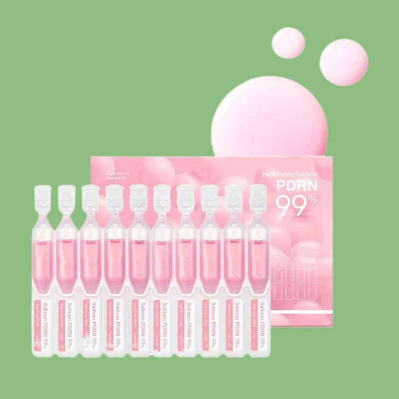 A pink bottle of PDRN Salmon DNA Anti-Aging Serum with multiple dropper vials and surrounding light pink spheres.