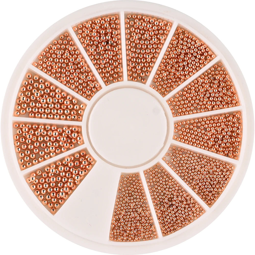 A circular tray of gold mixed stainless steel bead nail art decorations arranged in radial sections.