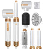 A collection of hair styling tools including a vertical dryer brush, round dryer, and various attachments.