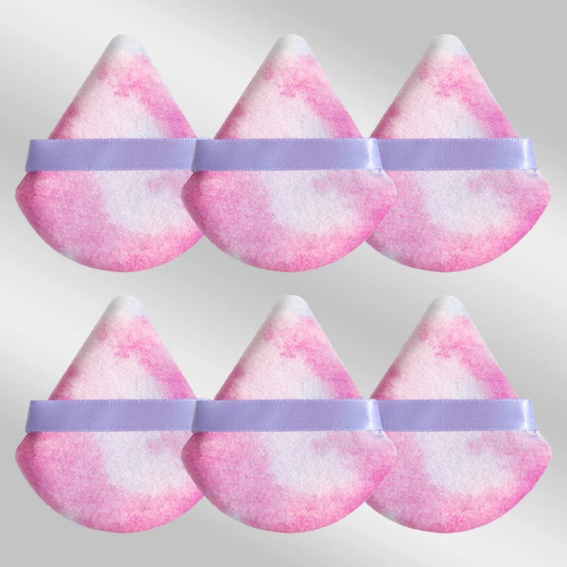 Un set de six éponges de maquillage triangulaires roses et blanches avec des élastiques violets.