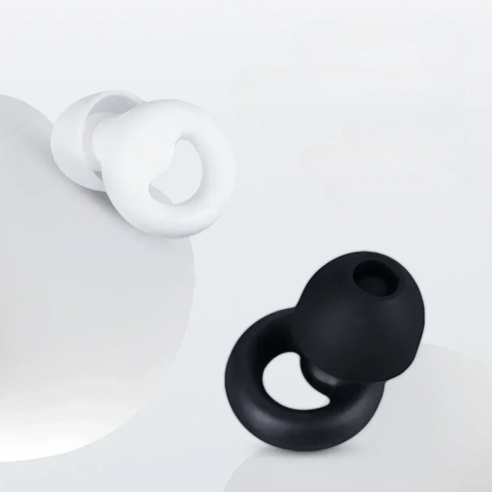 A pair of white silicone earplugs resting on a white surface.