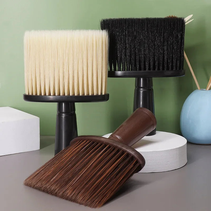 A set of black and beige soft bristle hair duster brushes displayed on a table.