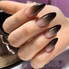 A hand displays almond press-on nails with a gradient finish featuring pink and brown tones.