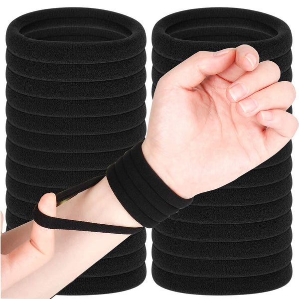 Une main tient un élastique noir, faisant partie d'une pile de bandes similaires.