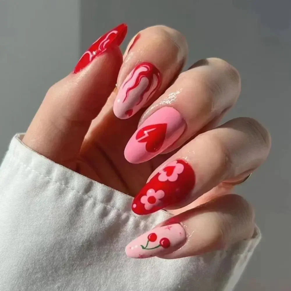 A hand displaying 24 press-on false nails with a pink and red wavy design on the fingernails.