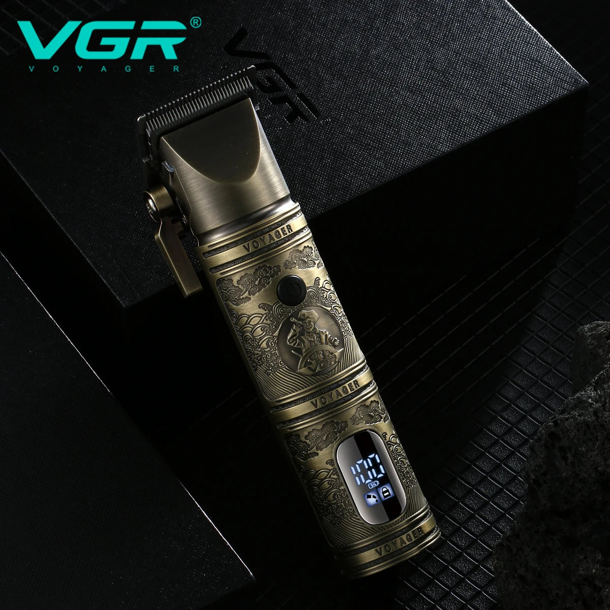 A bronze electric hair trimmer is shown lying on a dark surface with the VGR Voyager logo visible.