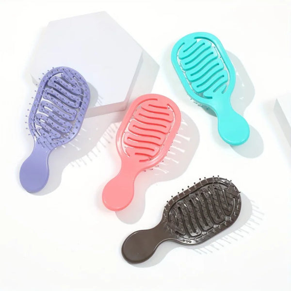 A collection of five mini travel hair brushes in purple, teal, pink, and gray are displayed on a white background.